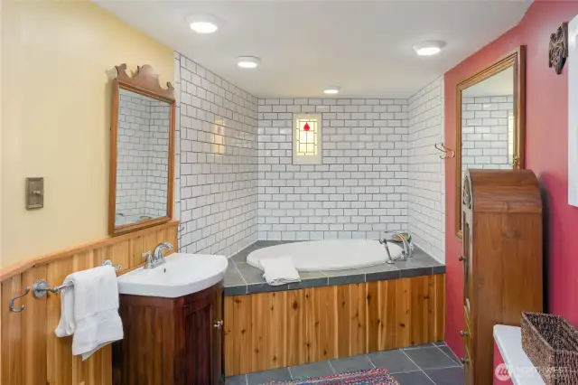 Lower studio bathroom with tub, macerating toilet.