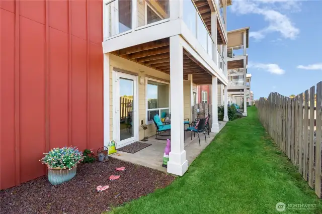 Grassy fenced in yard outside patio