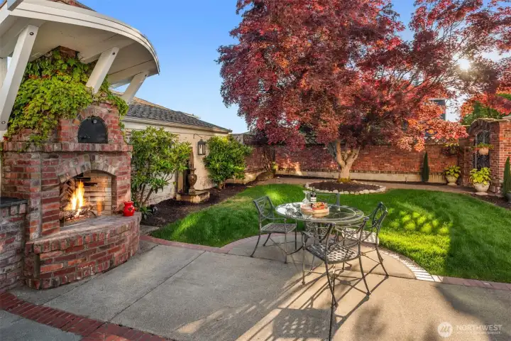 Step into the inviting backyard with old-world charm of a Tuscan villa, where dappled sunlight filters through mature maple trees. Ivy covered brick walls add privacy, making the patio with, BBQ grill,  the custom brick fireplace and pizza oven the perfect setting for sharing fine wine and memorable meals.