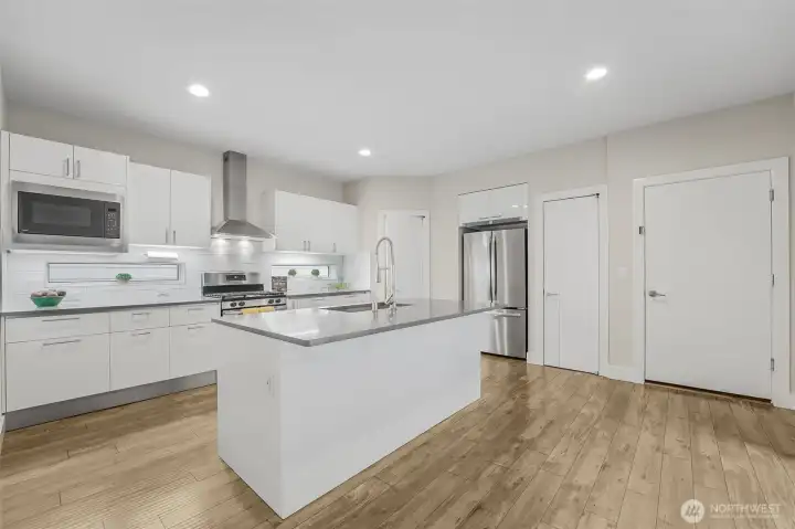 White piano finish cabinets w/Blum pull-down shelves and quartz countertops