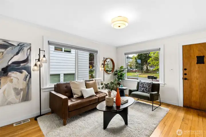 Living room with large picture windows and oak flooring