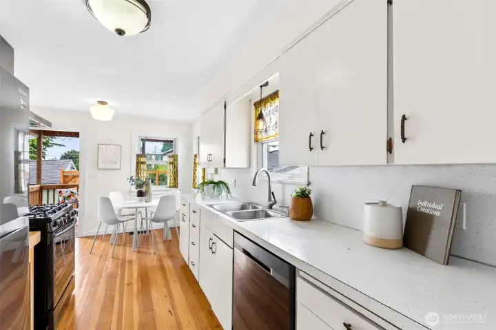Ample counter space, gas stove, refrigerator, and a dishwasher complete this kitchen