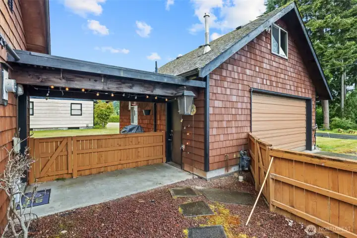 It's the little spaces that make a house feel like home.    This cozy courtyard offers privacy, character, and a welcoming transition between the home and the detached garage building.