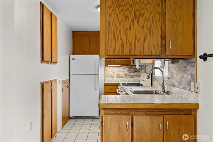 Not every great feature is flashy.    The built-in pantry shelving along the wall provides surprisingly useful storage for spices, canned goods, and everyday essentials—helping this compact kitchen live larger than you'd expect.
