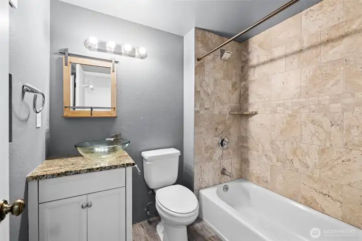 Thoughtfully updated with a contemporary vanity, vessel sink, and tile shower surround.