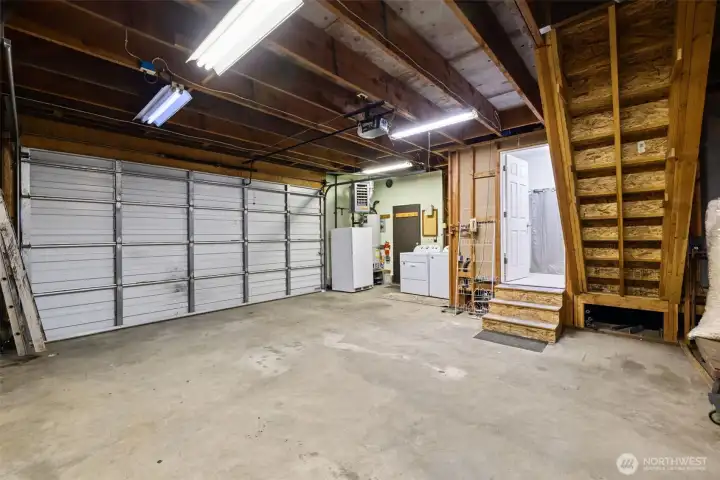 Generous garage space with built-in functionality, including laundry, a bathroom, and a large loft ready for your vision.