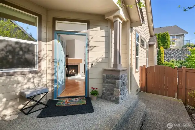 A covered front patio with the Craftsman style pillar and stone accents.  Notice the extra window above the front door to allow the natural light in.