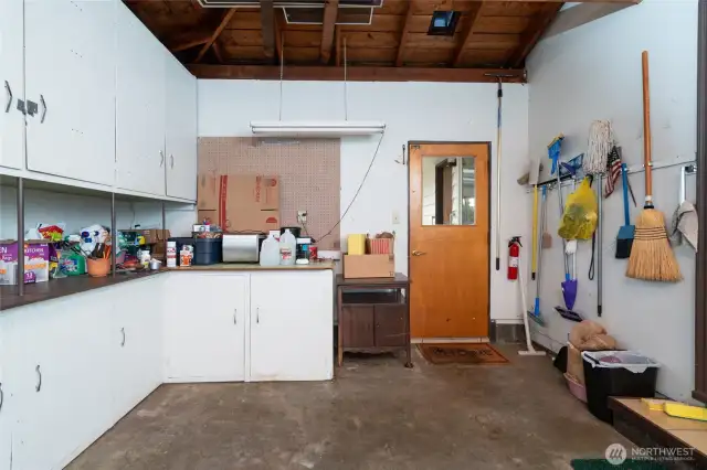 garage from a different angle, with tons of storage and room for a small fridge.  The door straight ahead leads to the sun room and the step up to the right leads to the kitchen.