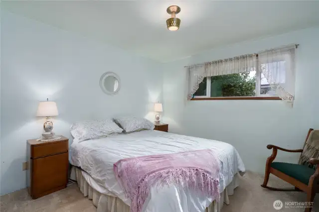 Cozy second bedroom, carpeted and view to the back yard.