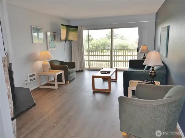 Living Room w/ LVP flooring, hide-a-bed couch and large slider to the private Deck.