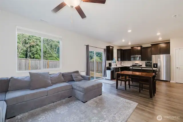 Spacious living room with ceiling fan and open flow to kitchen.