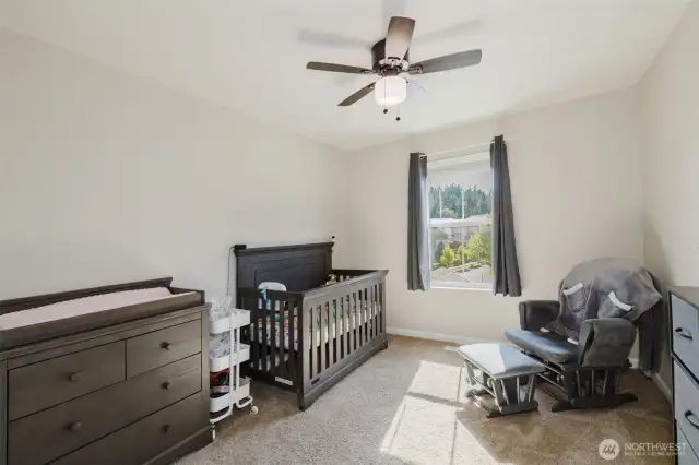 Versatile bedroom or office with bright windows.