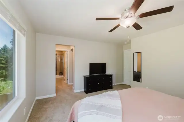 Primary bedroom with large window and direct bath access.
