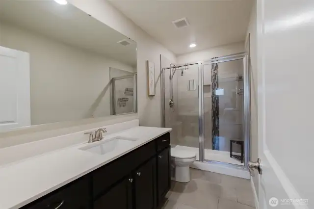 Primary bath with dual vanities and walk-in shower.