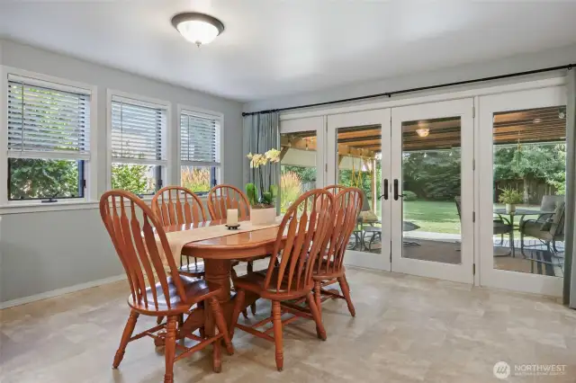 The dining area of the great room boasts these two walls of windows, and the incredible glass doors that open wide to the covered deck!