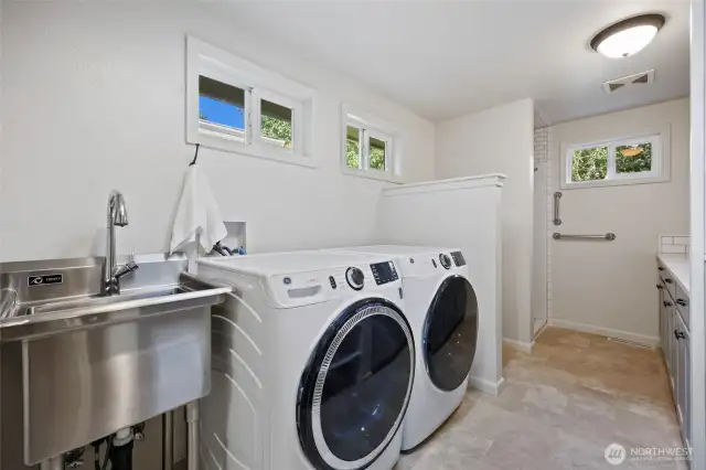 Just off the kitchen and great room is this AMAZING mud room/pantry with 3/4 bath! You can peep the counter and cabinets which offer terrific storage and folding space.