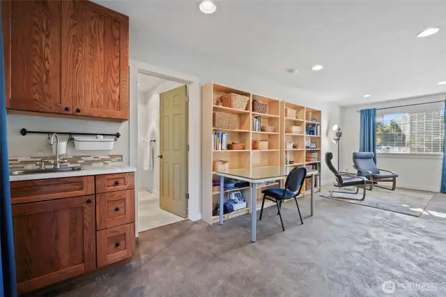 Counter with sink and cabinets in the corner could be added to if a kitchenette for ADU is desired. The bookshelves can stay.