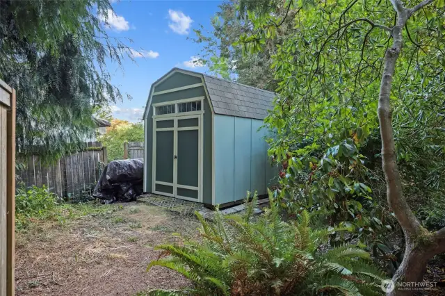Tucked behind bushes in the corner is this very convenient shed; easy to access yet remains out of sight!