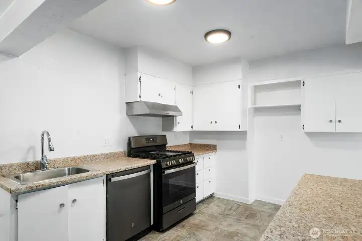 Ample cabinet and counter space with a mix of open shelving and closed storage.