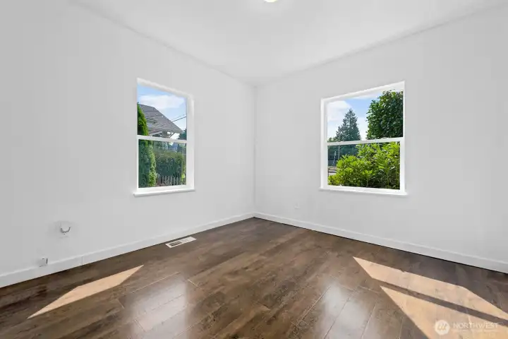 Spacious corner bedroom with dual windows for abundant daylight and garden views