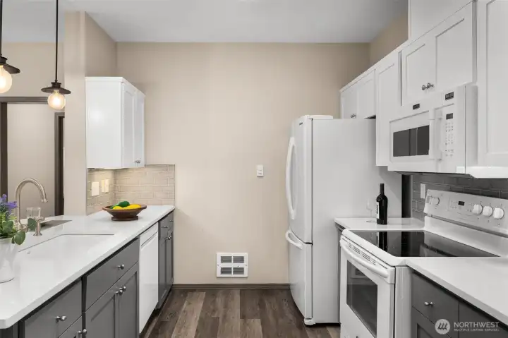 Updated kitchen has quartz counters & shaker-style soft-close cabinets