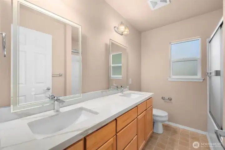 Ensuite bathroom in primary bedroom, with new countertop, faucets, and frameless anti-fog mirror.