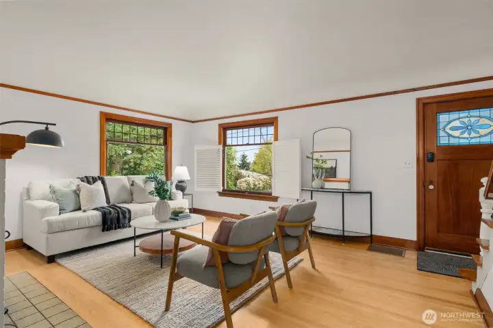 Custom window treatments let in light but maintain privacy.  Vintage stained glass inset in the front door.