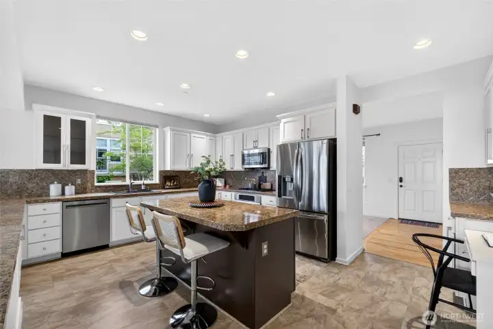 Thoughtfully designed with abundant cabinetry, stainless steel appliances, and extensive prep areas, this kitchen delivers both style and functionality. The oversized island anchors the space, providing additional seating and a natural gathering point.