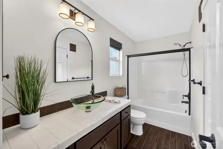 A well-designed Jack and Jill bathroom connects the secondary bedrooms, featuring a full tub and shower combination along with a spacious vanity. The layout offers both convenience and privacy for shared use.
