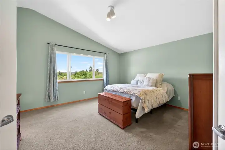 The primary bedroom is large and boasts vaulted ceilings.