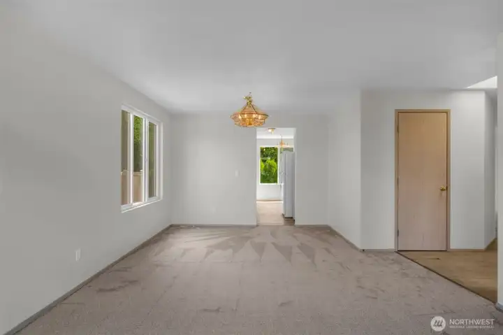 Hall closet off of entry. Living room with view to dining room and kitchen.