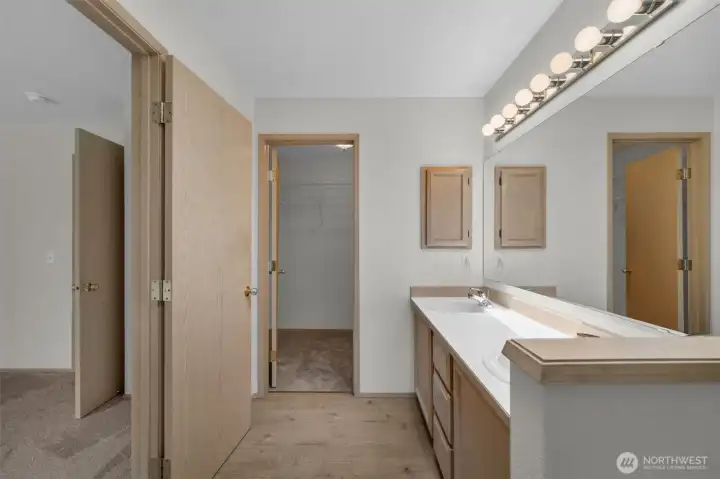 Primary bathroom leading into private walk in closet.