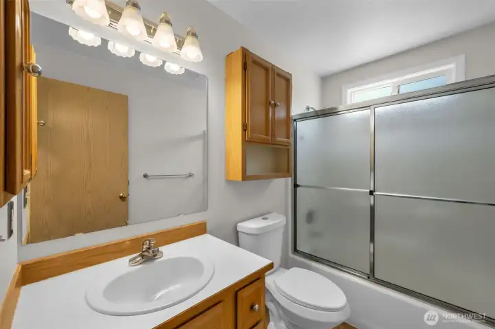 Hall bathroom with shower enclosure and storage.