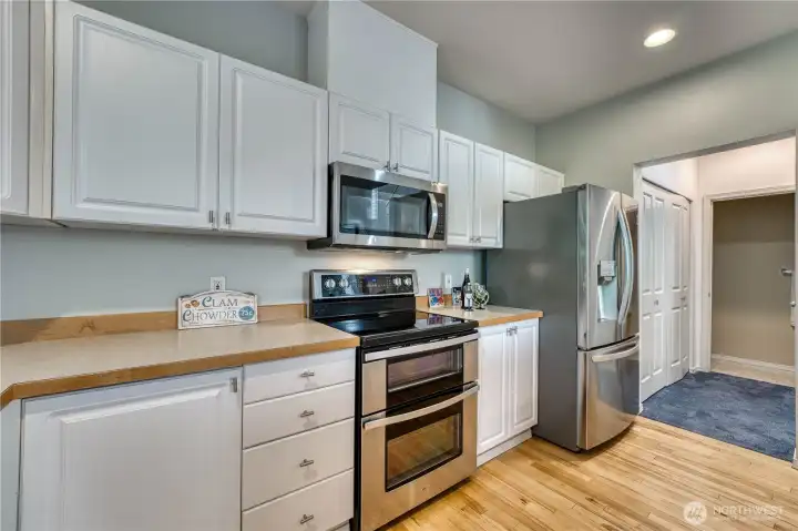 Another view of the kitchen showing the hallway. Double doors on the left include full size washer and drier. Coat closet to the right and half bath straight ahead. Another view of the kitchen showing the hallway. Double doors on the left include full size washer and drier. Coat closet to the right and half bath straight ahead.