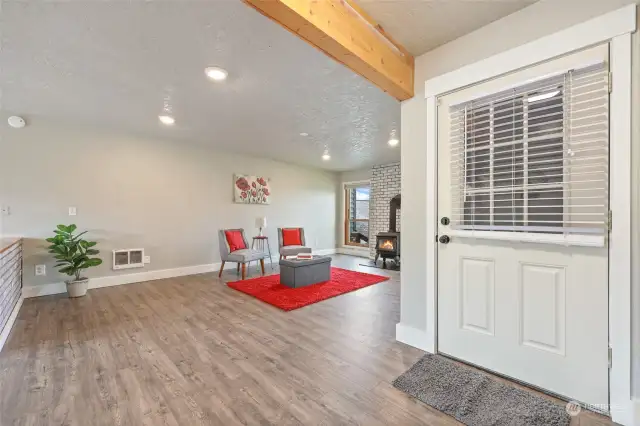 Cheery entry to this spacious living room with exposed beam above and laminate flooring below.