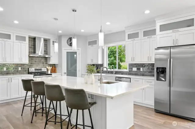 Upgraded appliances, quartz countertops, an abundance of cabinets and a walk in pantry highlight the kitchen.