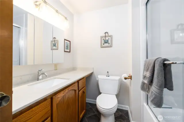 Guest full bath with new tub/shower unit and quartz countertop.