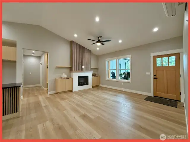 Enter the 1,416 sf open concept plan with vaulted ceilings, fireplace wall flanked by shelves, and luxury vinyl plank flooring.
