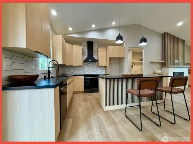 The kitchen features gorgeous cabs, stainless appliances, Quartz slab countertops, tiled backsplash and island/breakfast bar.