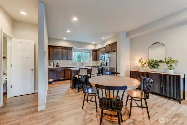 Nestled between the great room and kitchen is the dining area.  This area would be great for any style of table.  On the left is the half bath for this floor.