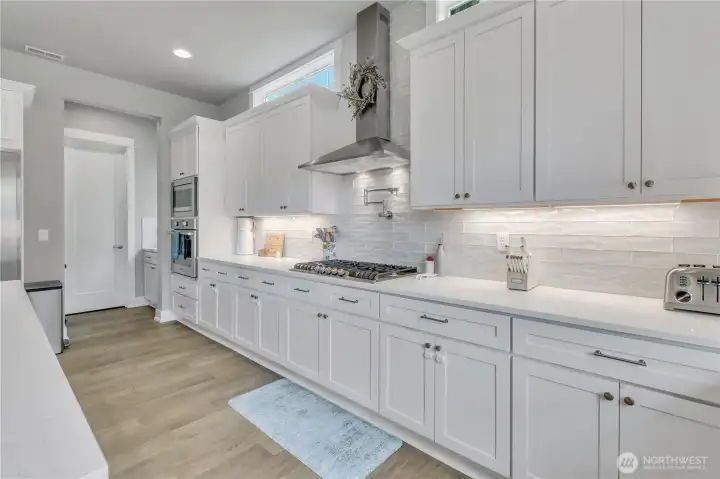 Gas range with pot filler above for convenience and style. Walk-in pantry offering exceptional storage space. Gas range with pot filler above for convenience and style. Walk-in pantry offering exceptional storage space.