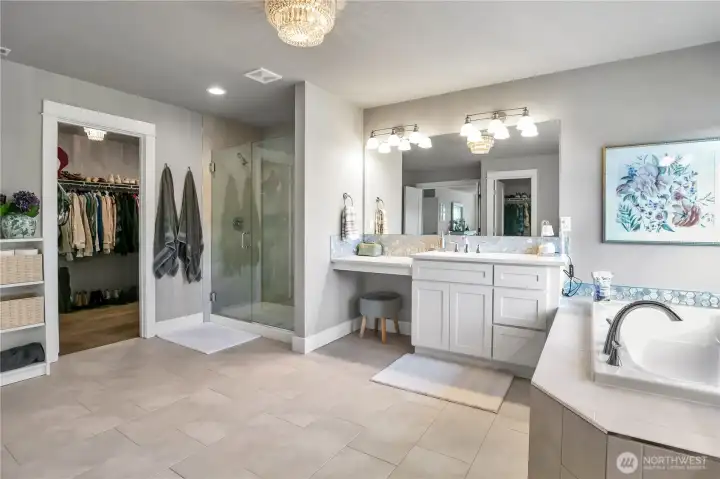 Another view of the primary bath with walk-in closet and separate shower.