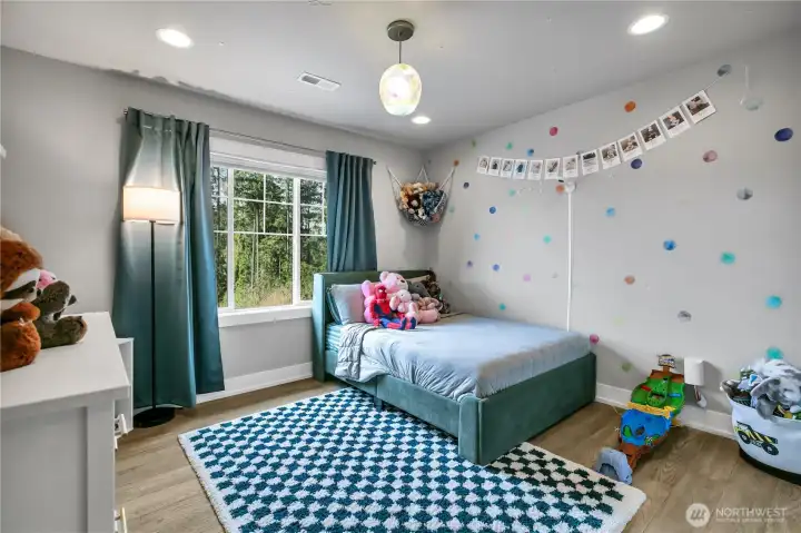 Upper-level bedroom with natural light and scenic view.