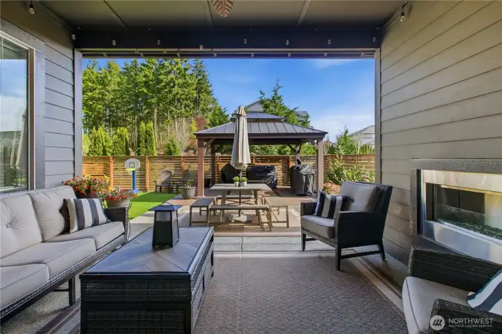 Covered patio with outdoor fireplace for year-round enjoyment.