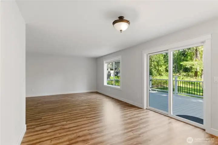 Bright living room with large windows and deck access.