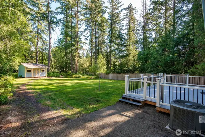 Rear exterior highlighting level lawn and natural surroundings.