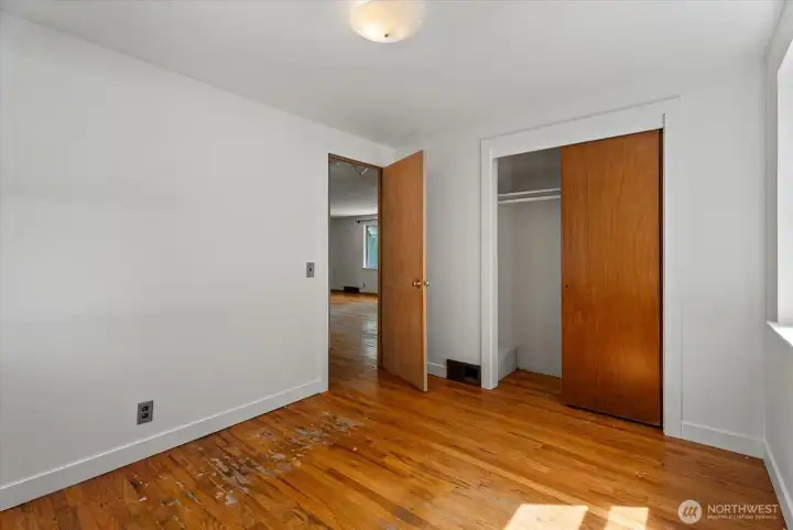 Another shot of the second main floor bedroom with hardwood flooring, closet storage, and flexible space for guests, a home office, hobbies, or everyday living.