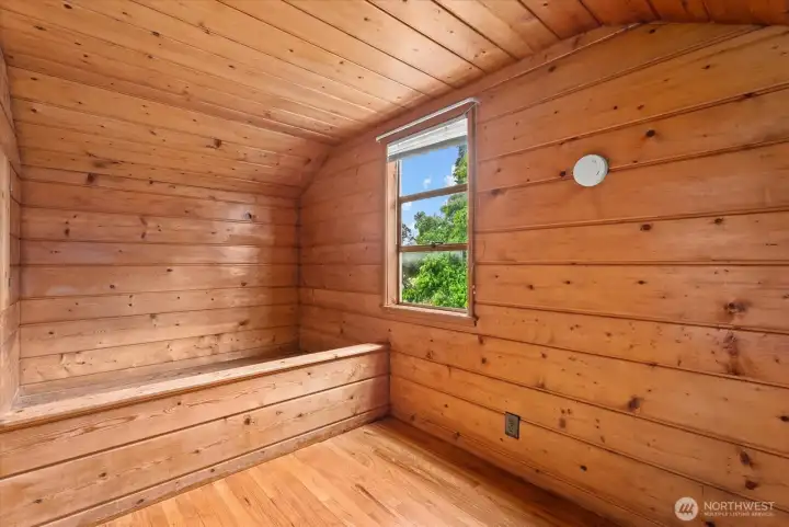 Wood-paneled room with built-in storage, bench seating, and distinctive character.