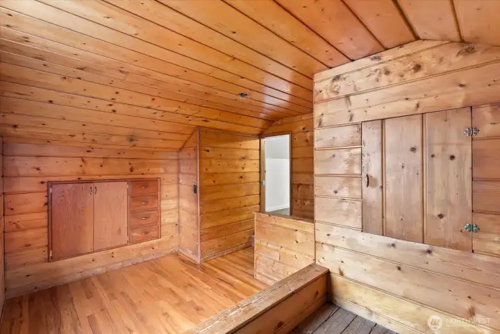 Additional view of the wood-paneled room highlighting the built-in cabinetry and storage features.