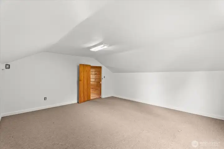 Expansive upstairs bedroom  offering flexible space for recreation, hobbies, work, or guests.